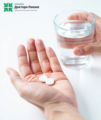 Стакан воды и таблетки в руке